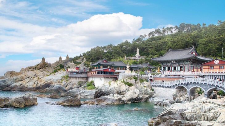 South Korea's only seaside temple, Haedong Yonggung nestles in the rocks on the coastline near Busan, backed by green forest, the blue waters of the sea lapping close by.