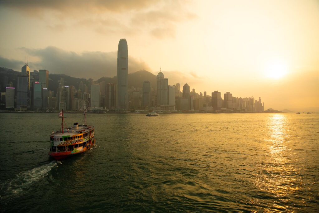 The sun sets over Victoria Harbour as a Star Ferry makes its way across the water towards the skyscrapers of Central, Hong Kong. 