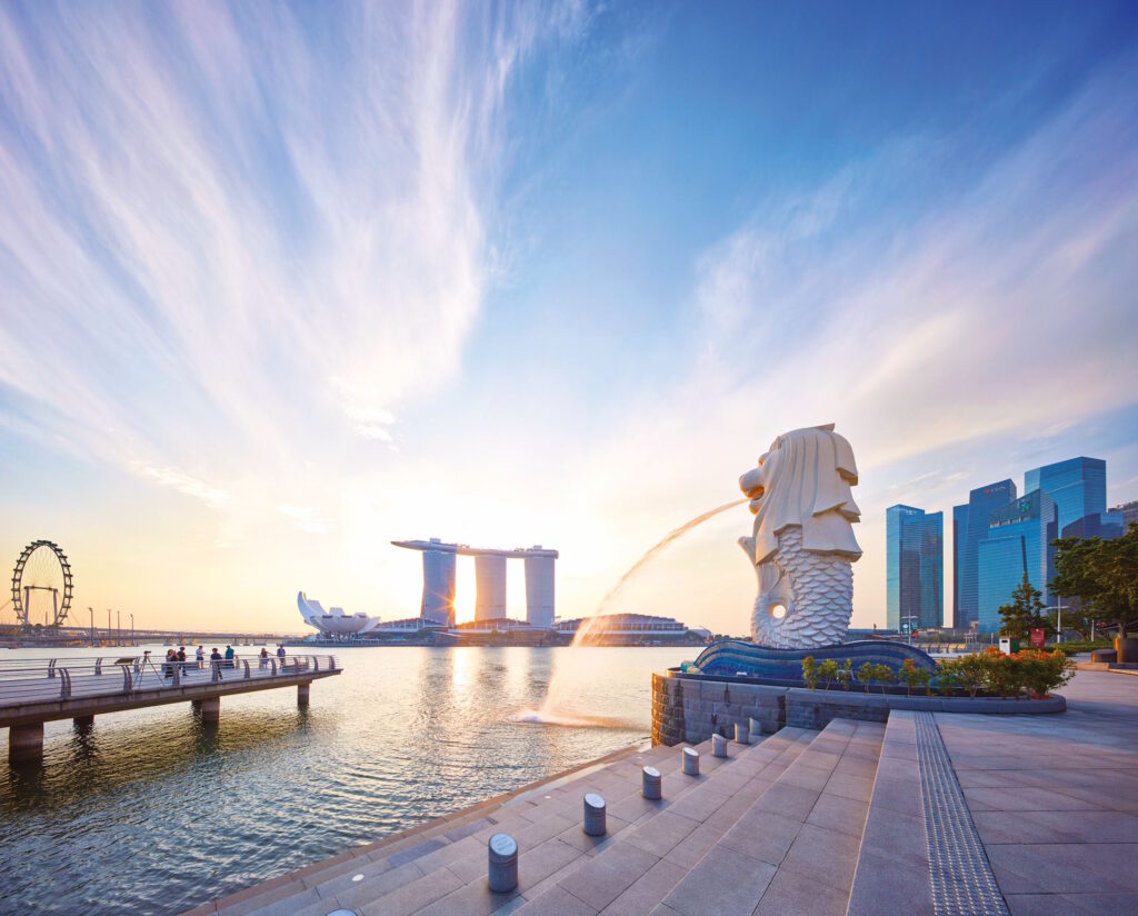 Merlion statue at Marina Bay with Marina Bay Sands and the city skyline at sunset.