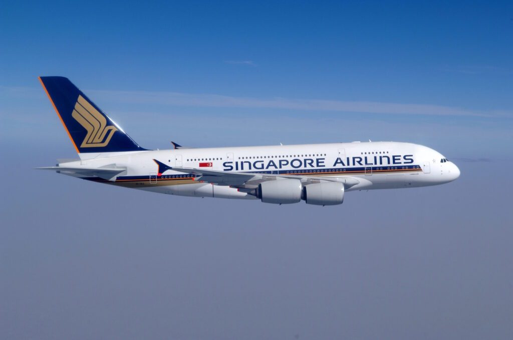 Singapore Airlines Airbus A380 in flight, showcasing its sleek design, signature livery, and double-decker structure against the sky.